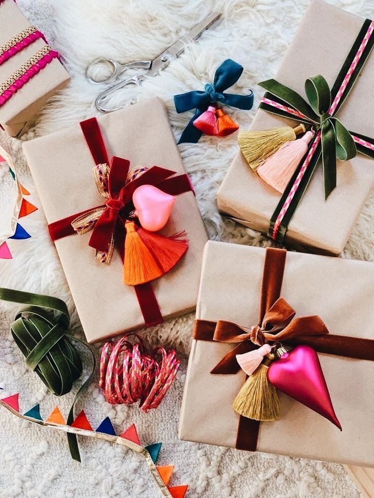 A bunch of wrapped presents with holiday tassels and ribbons.
