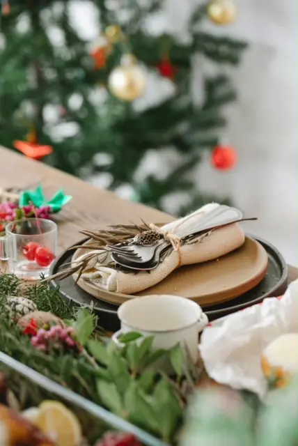 A table setting with a christmas tree and decorations.