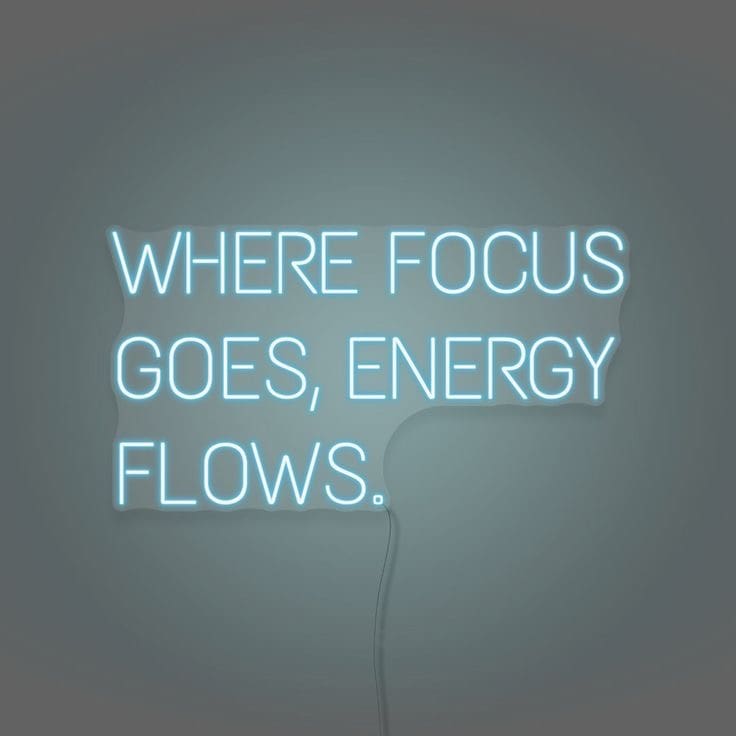 neon sign saying 'where focus goes energy flows'