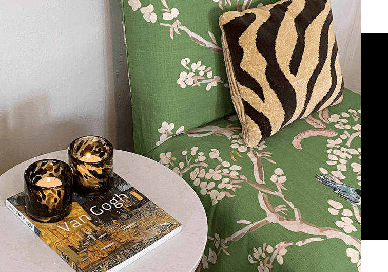 A green chair with a zebra print pillow and a white table.
